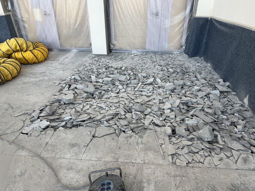 Ein Fliesenboden, in großen Teilen in kleine Stücke geklopft.