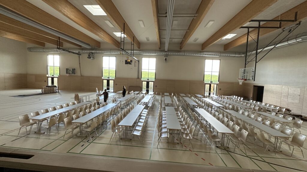 Ein Überblick über die Halle mit gestellten Tischen und Stühlen, wie es für den Auftritt vorgesehen ist.