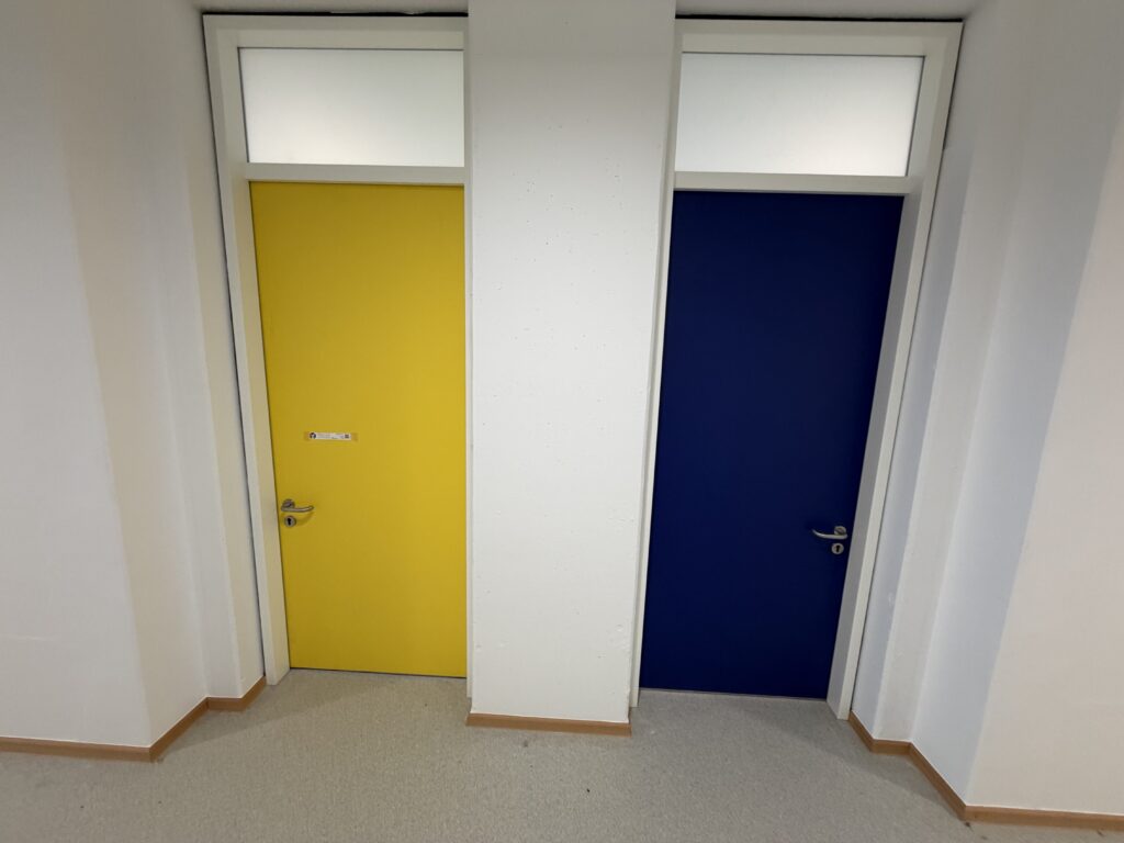 links eine gelbe, rechts eine blaue Tür